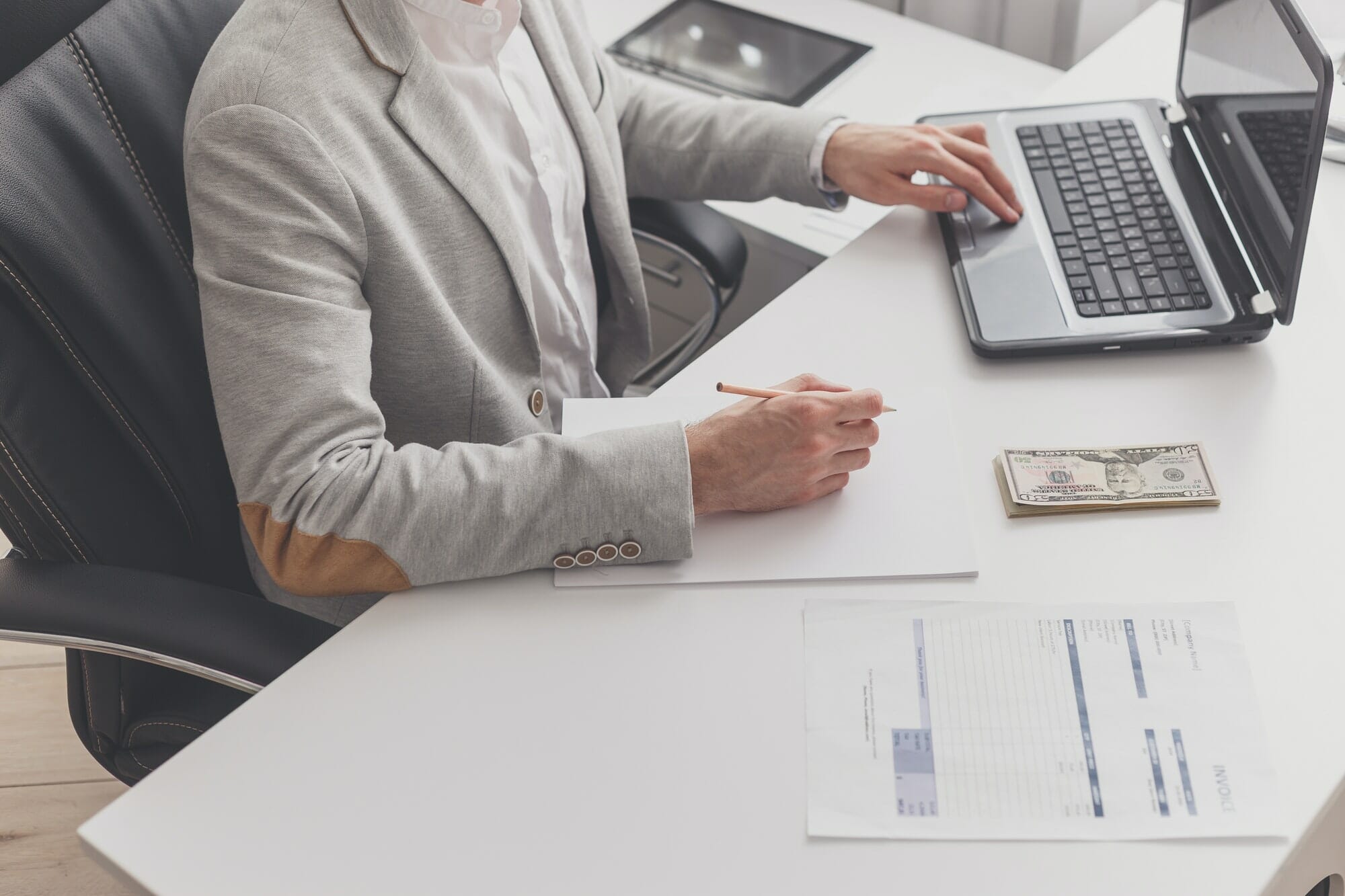 A male accountant works at a pc in an office at home.